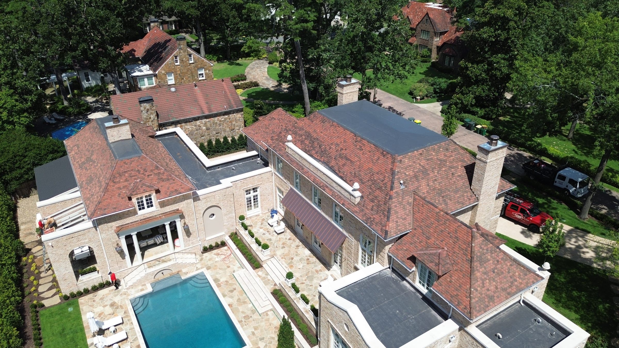 Estate with clay tile roof and flat roof sections, aerial view