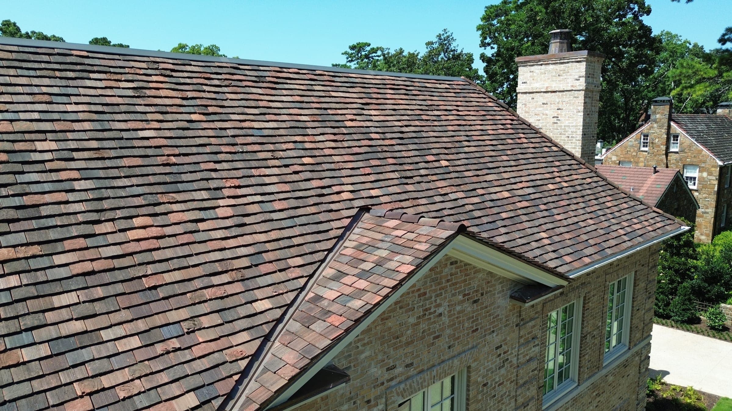 Close detail of weathered clay roof tile texture beside a chimney