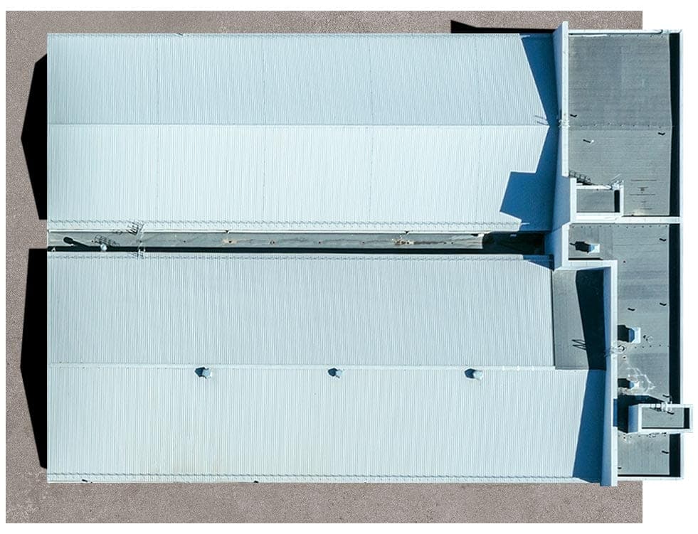 Top-down view of a flat roof with a light-colored membrane