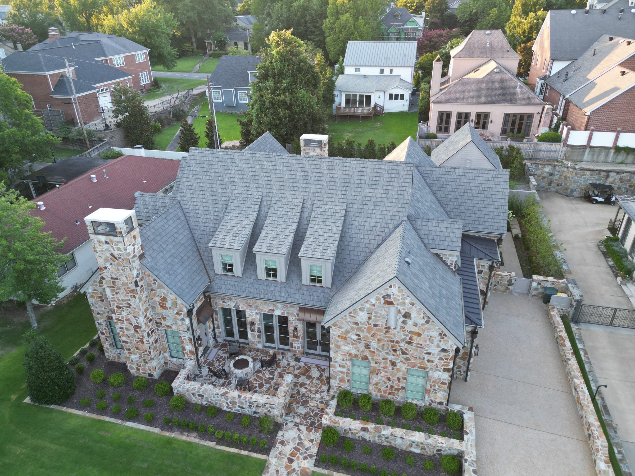 Stone home with slate roof and three dormers seen from above