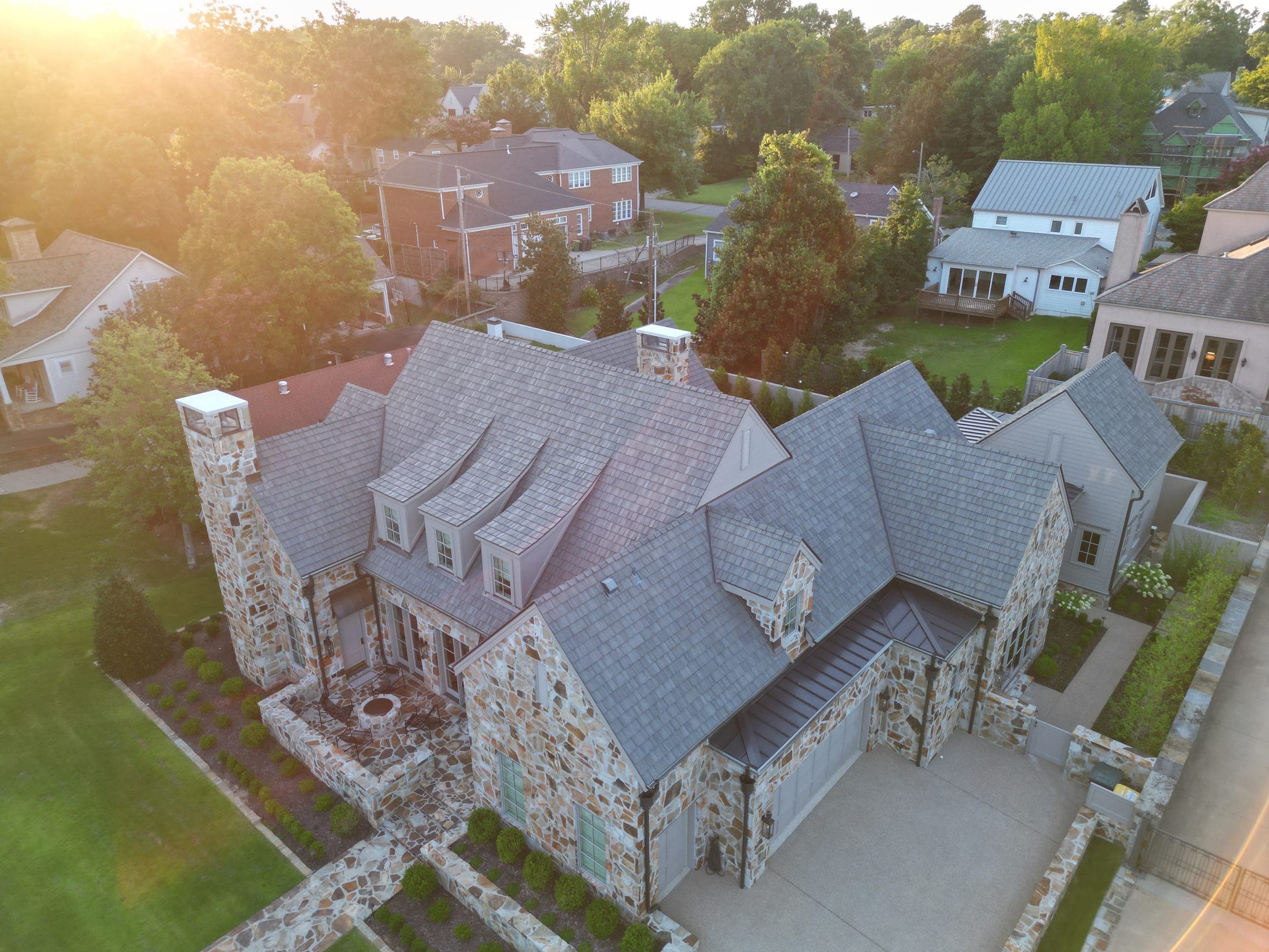 Stone home with slate roof at golden hour in a Central Arkansas neighborhood