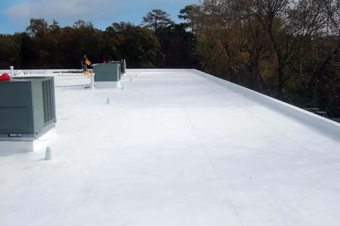 White membrane commercial flat roof with rooftop HVAC equipment