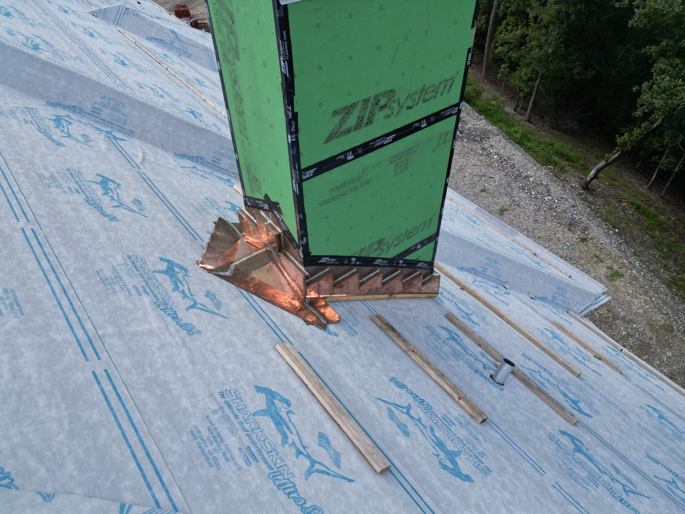 Copper chimney flashing installed over new roof underlayment