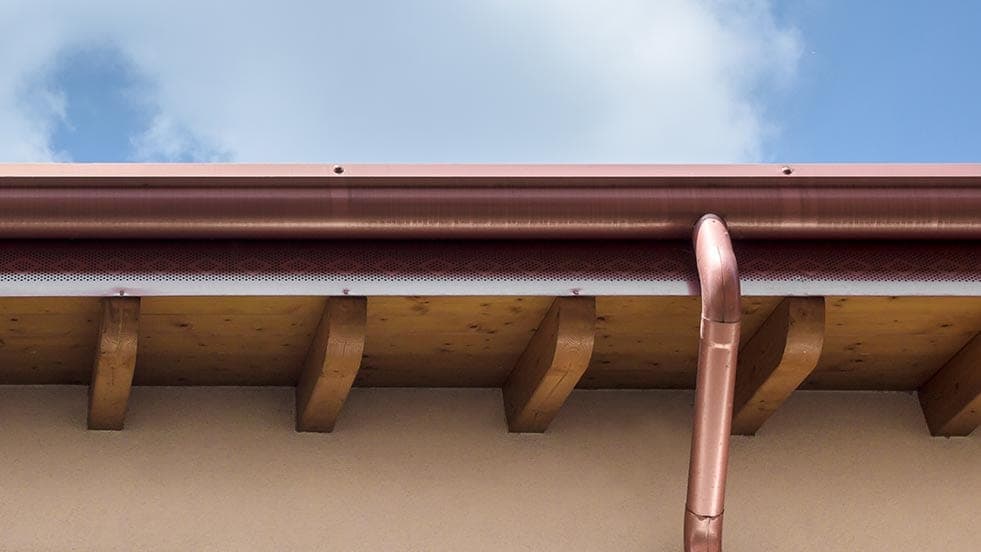Copper gutter and downspout on a brick home