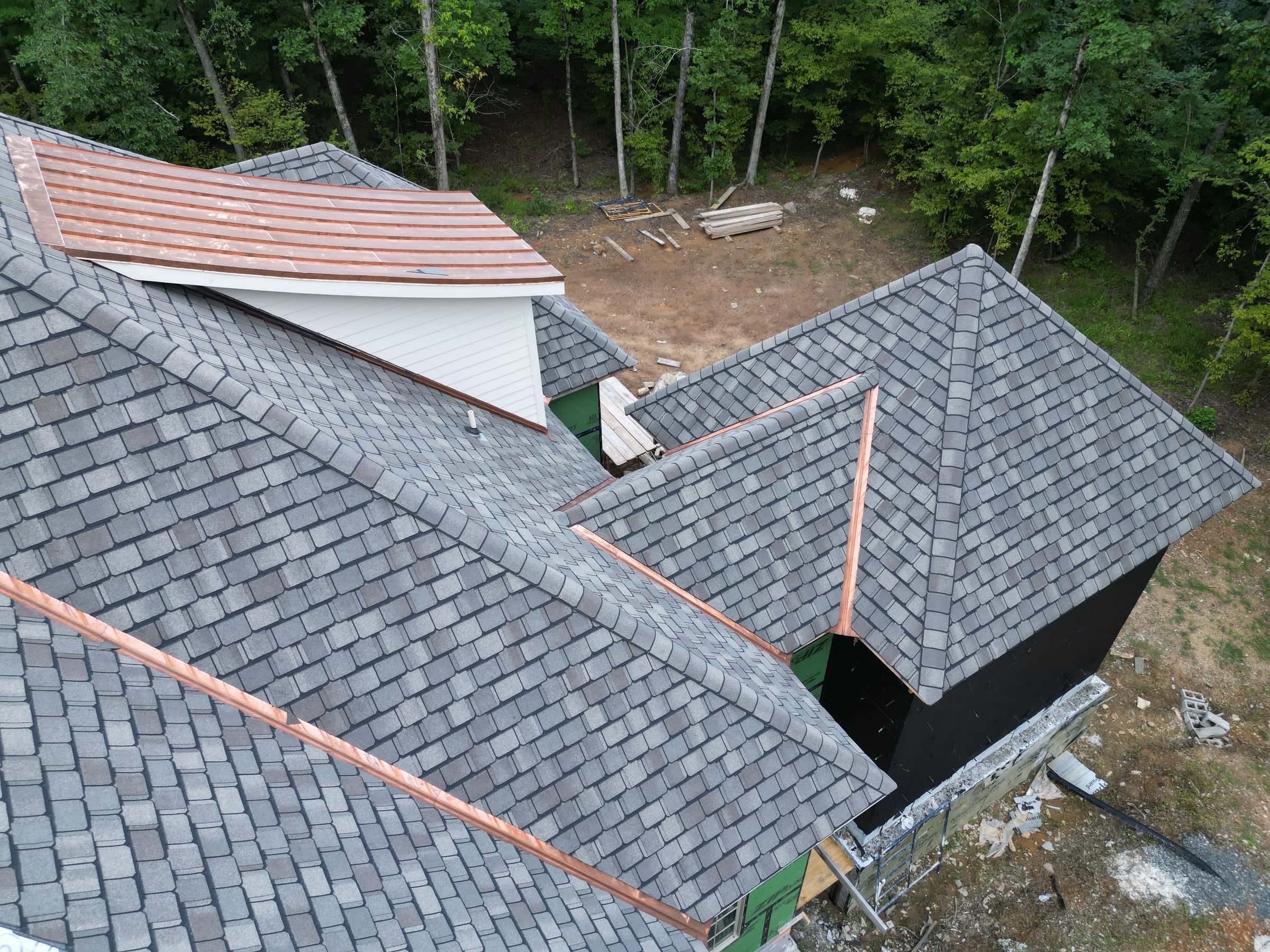 Copper valley flashing running between slate-look roof planes beside a dormer