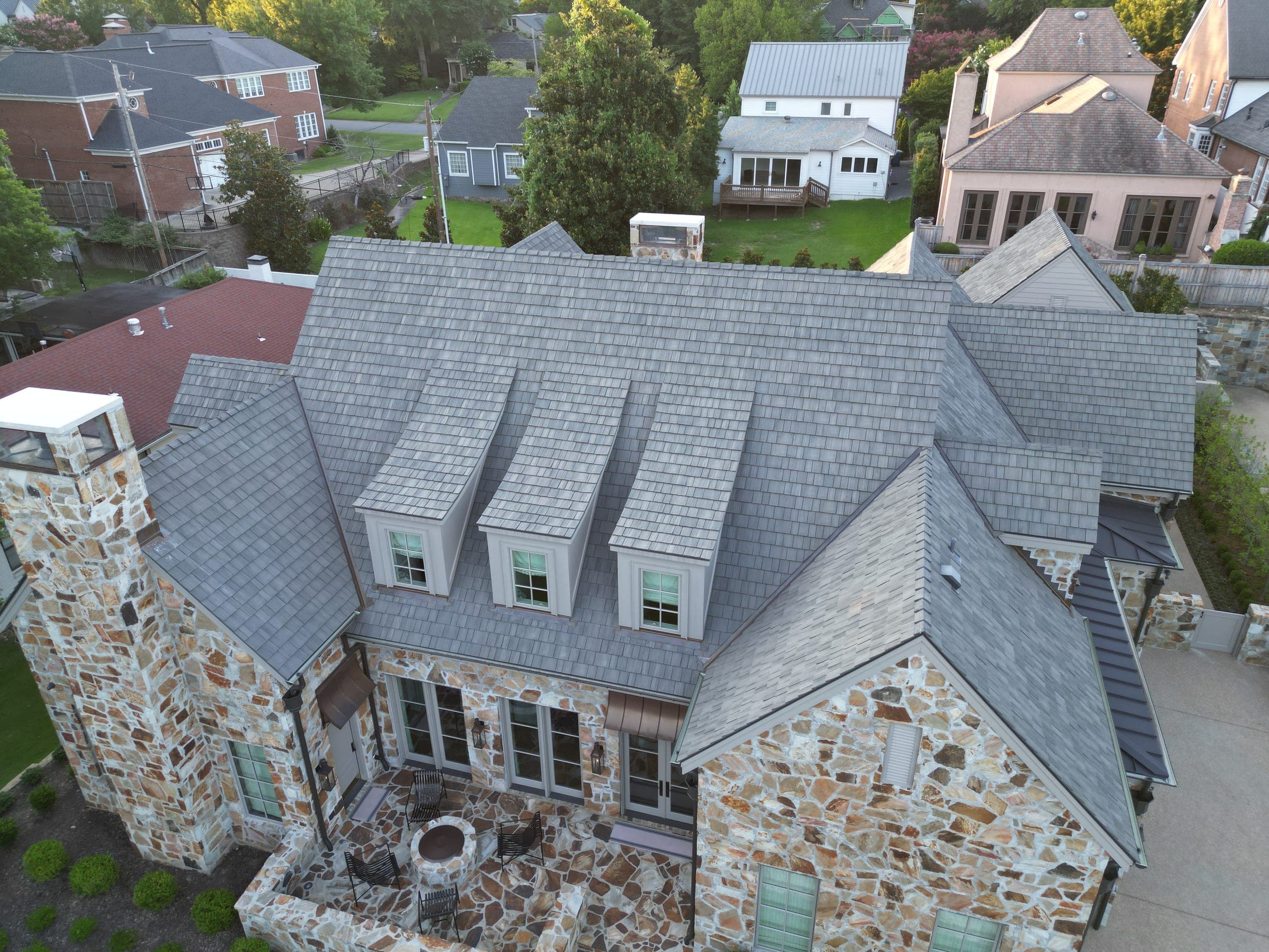 Aerial view of a stone home with a slate roof in Central Arkansas